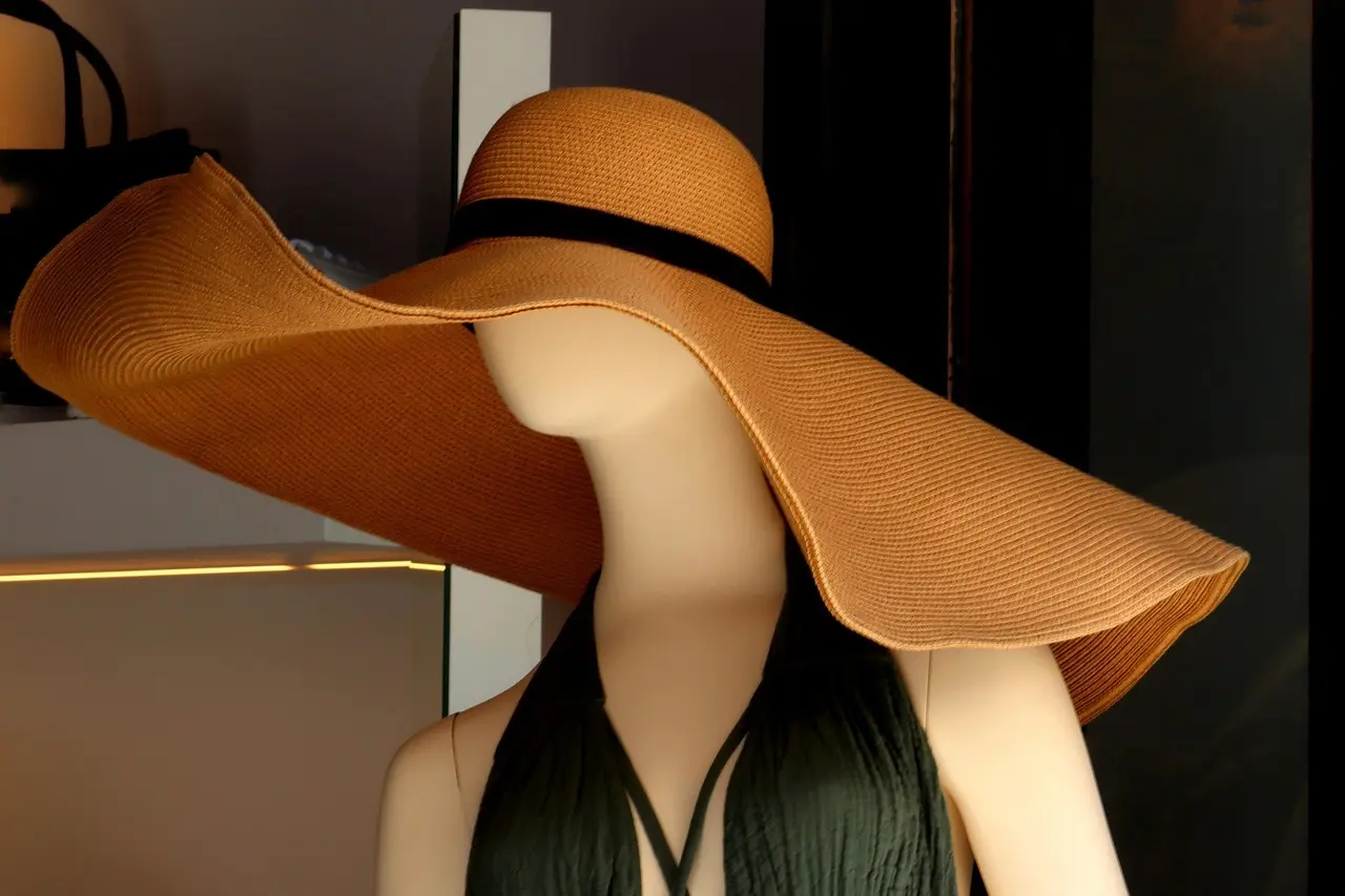 Mannequin med en stor stråhat som dekorativt blikfang